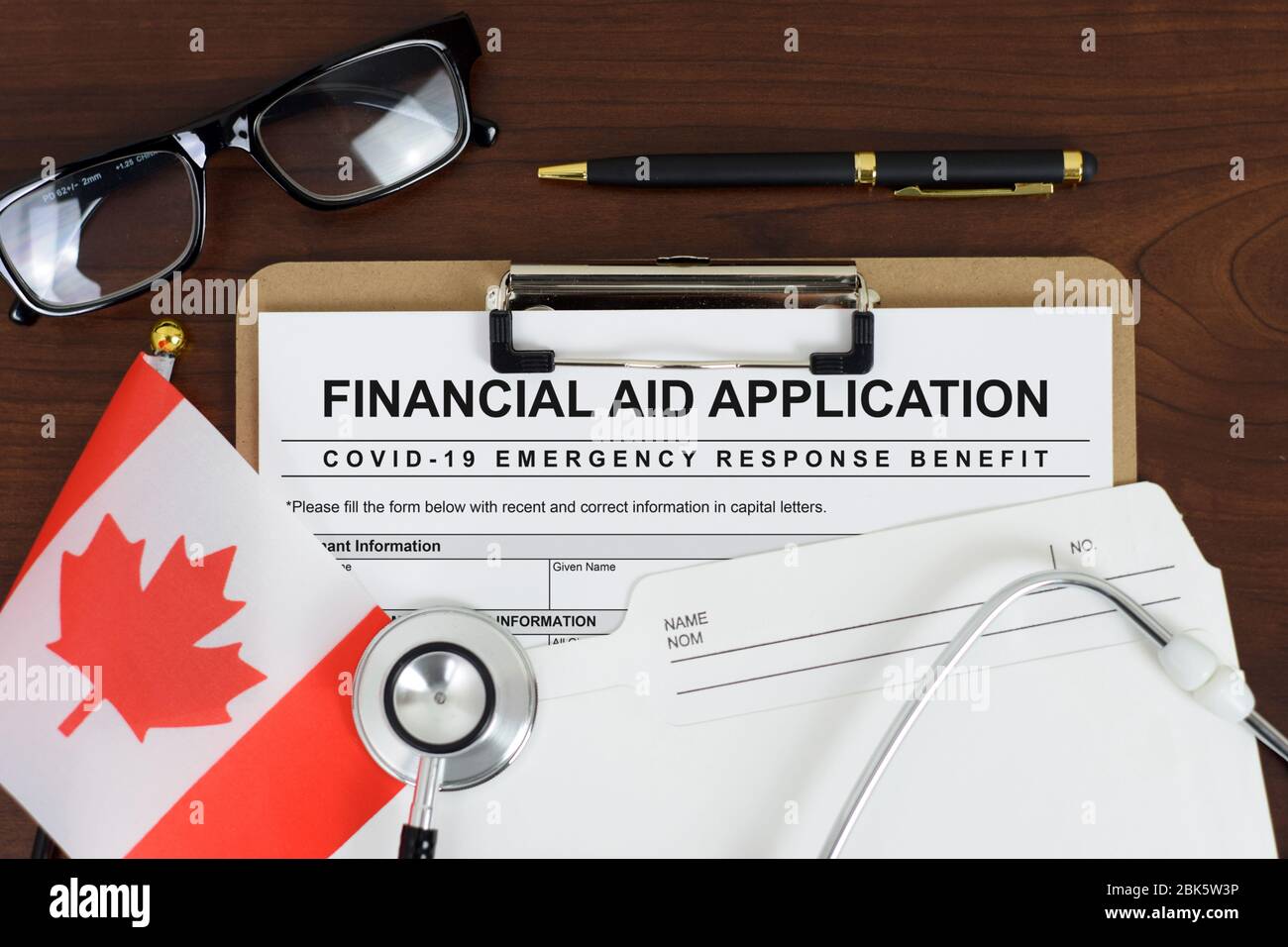 Illustrative concept image for Covid-19 (Coronavirus) pandemic. Mock-up financial aid application form with Canadian flag and stethoscope. Stock Photo