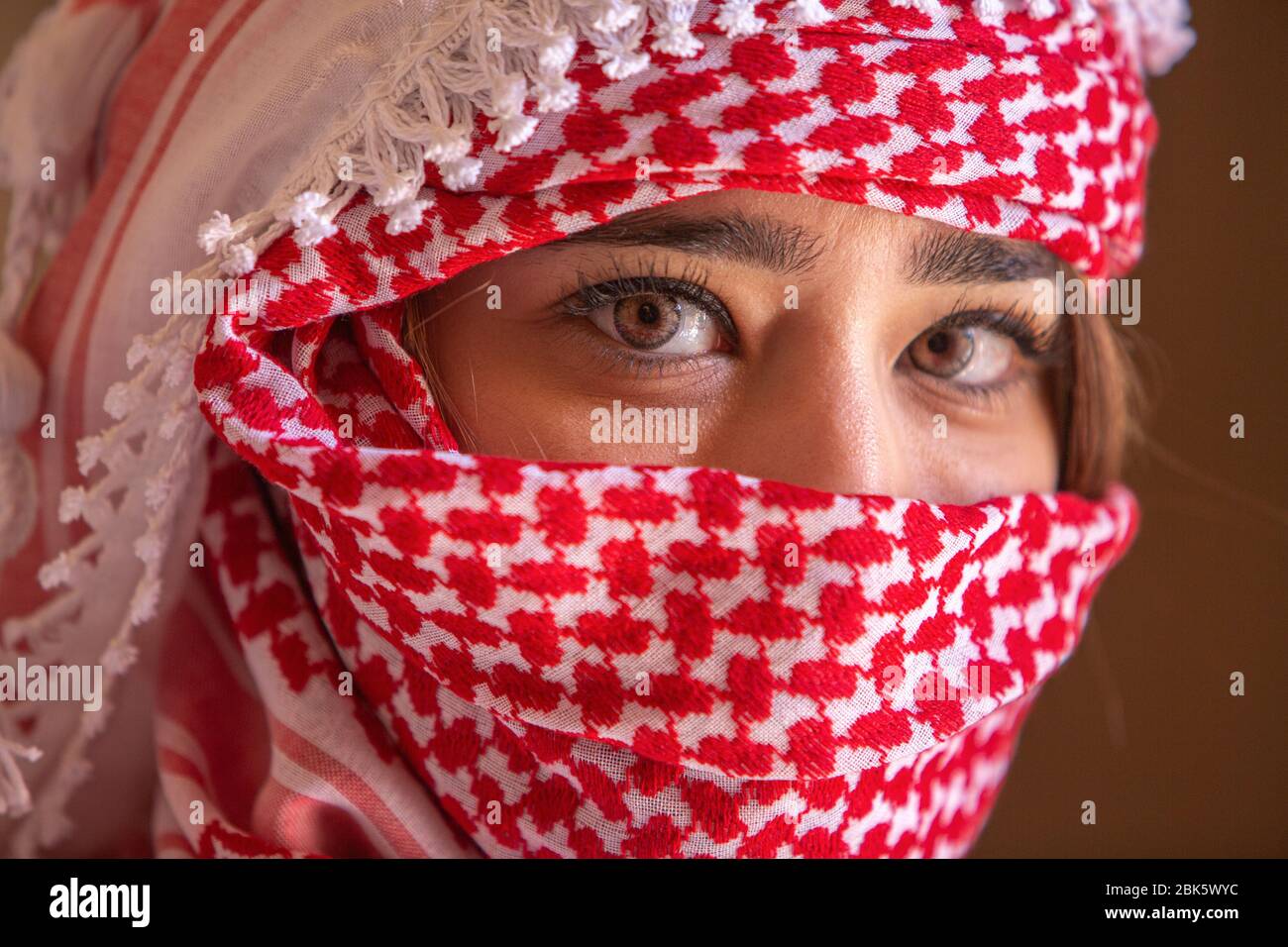 Young Jordanian woman wearing traditional keffiyeh head scarf at Jerash, Jordan Stock Photo