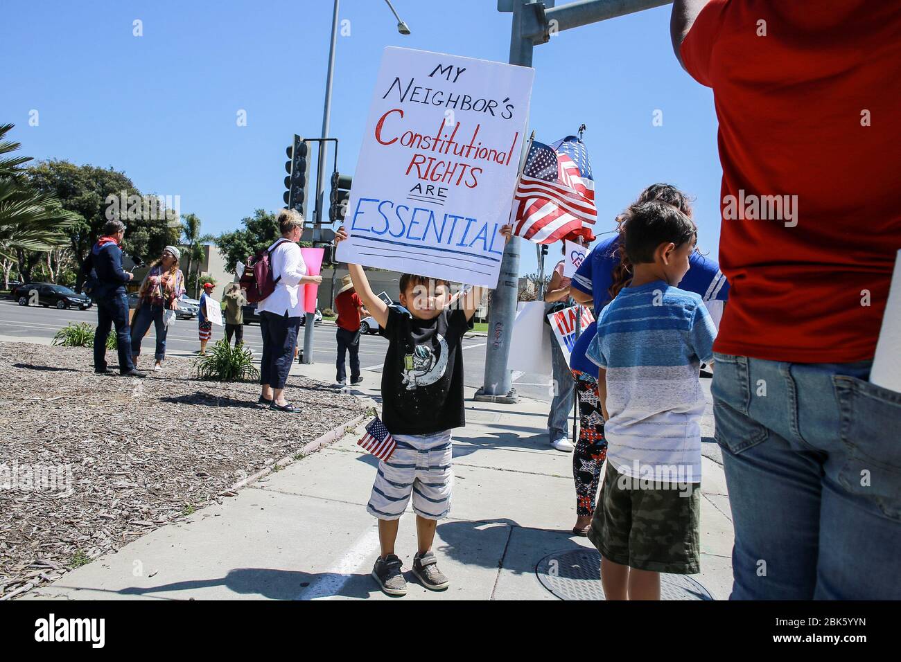 Ventura, United States. 01st May, 2020. A child holds a placard that says My Neighbours Constitutional Rights are Essential during the demonstration.People gathered at the Ventura County Government Center to protest the California Stay At Home Orders amid the Coronavirus (Covid-19) outbreak. Credit: SOPA Images Limited/Alamy Live News Stock Photo