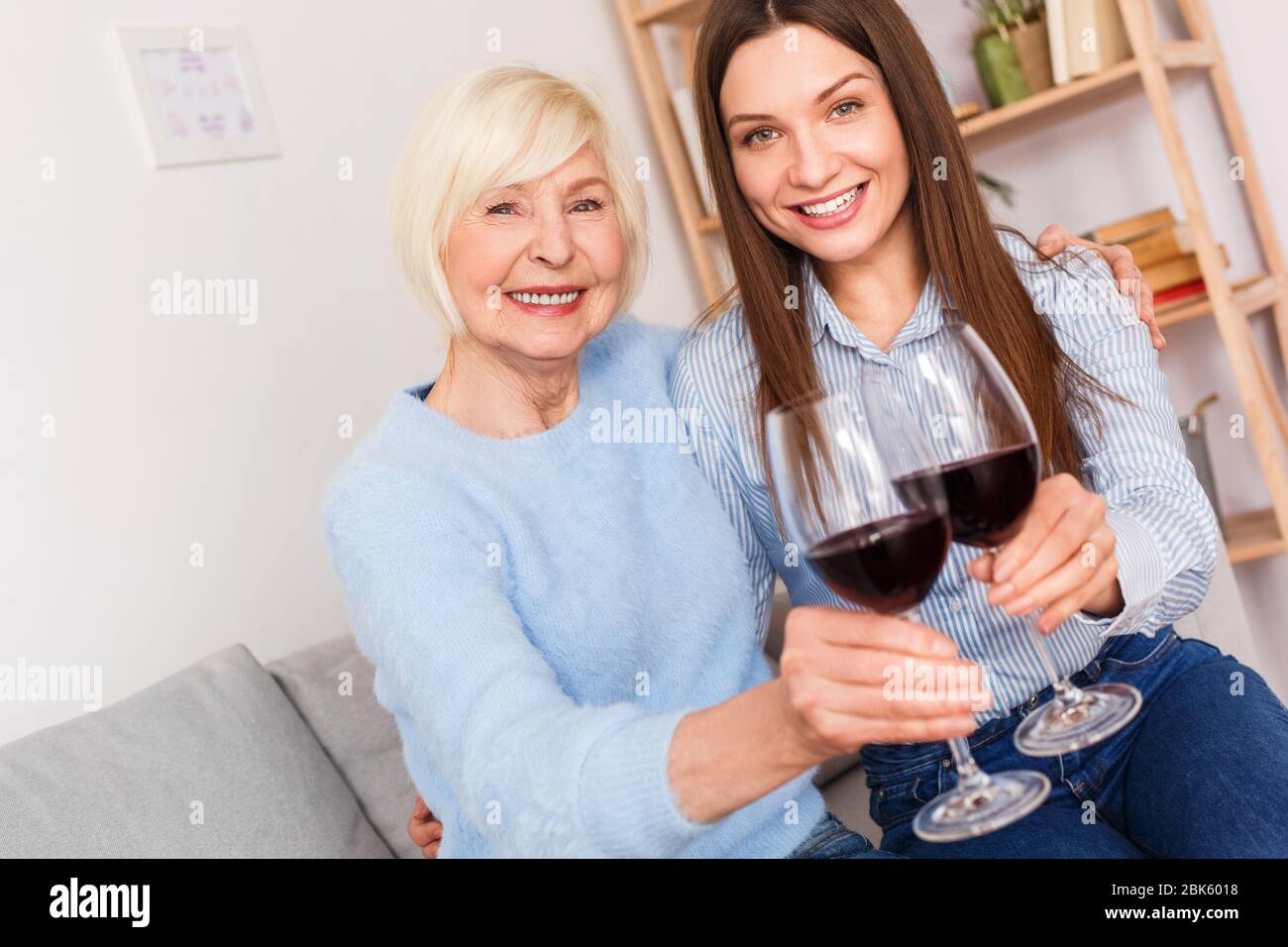 Adult woman and her senior mother with wine glasses in hands Stock Photo