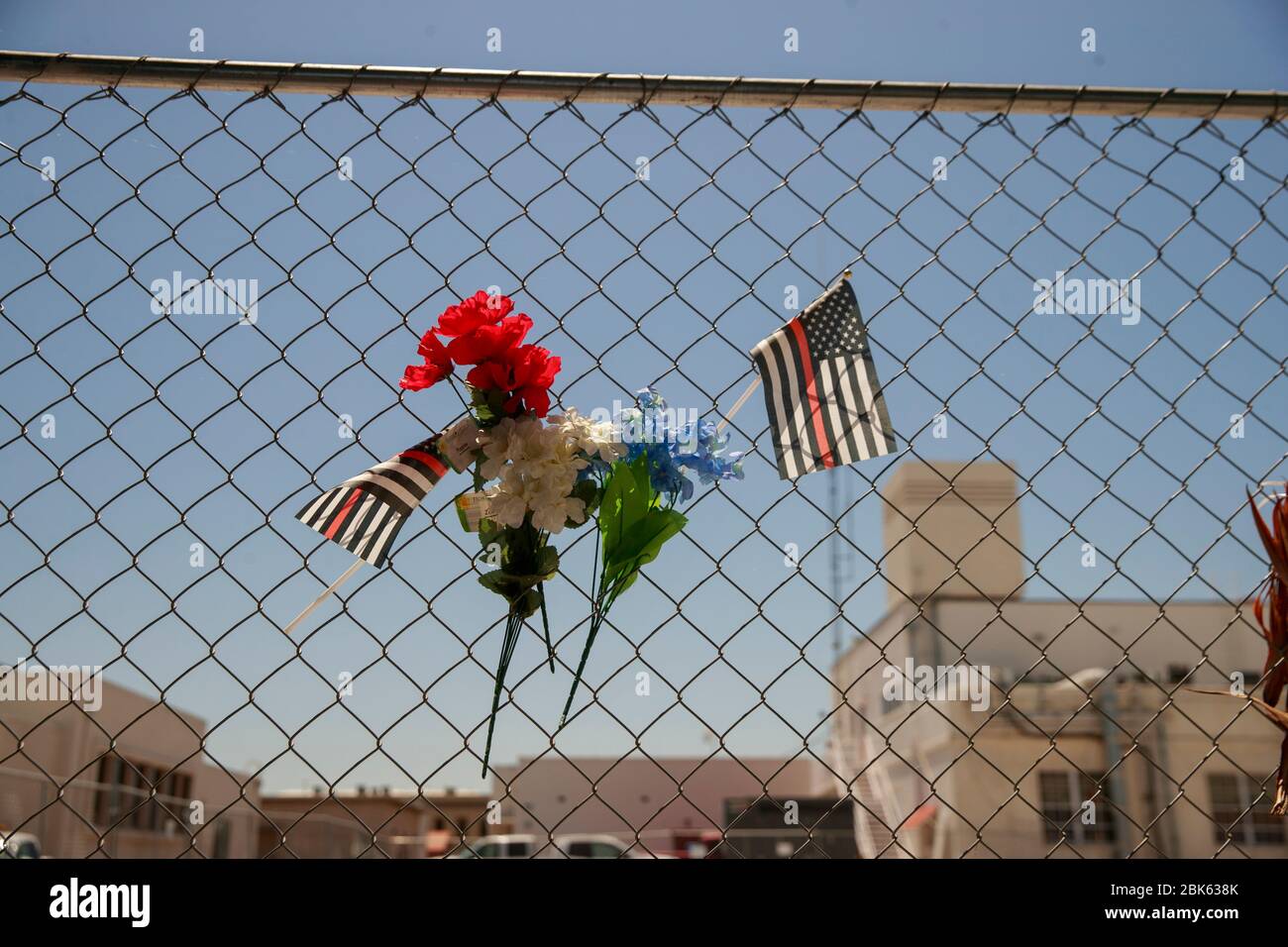 Memorial flags and flowers decorate a chain-link fence around the site of  the Porterville Public Library which was burned down. Two firefighters,  Capt. Raymond Figueroa, 35, and Patrick Jones, 25, died while