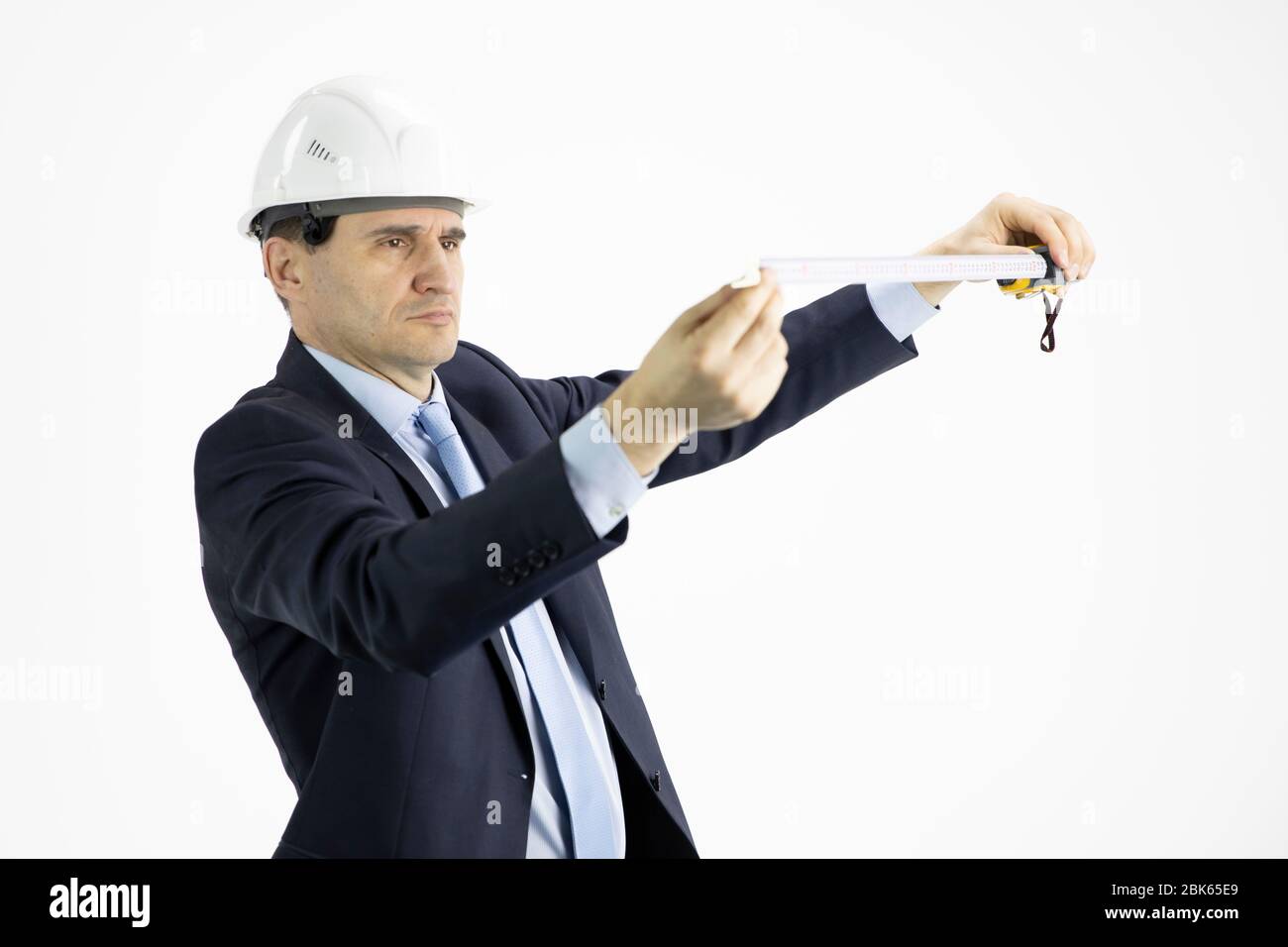 Serious architect measures with tape measure on isolated white