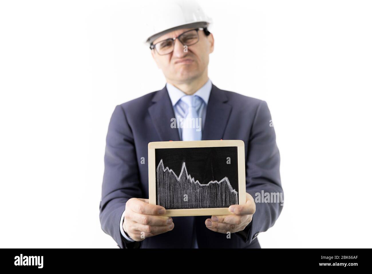 Displeased businessman holding sign with falling chart of oil quotes ...