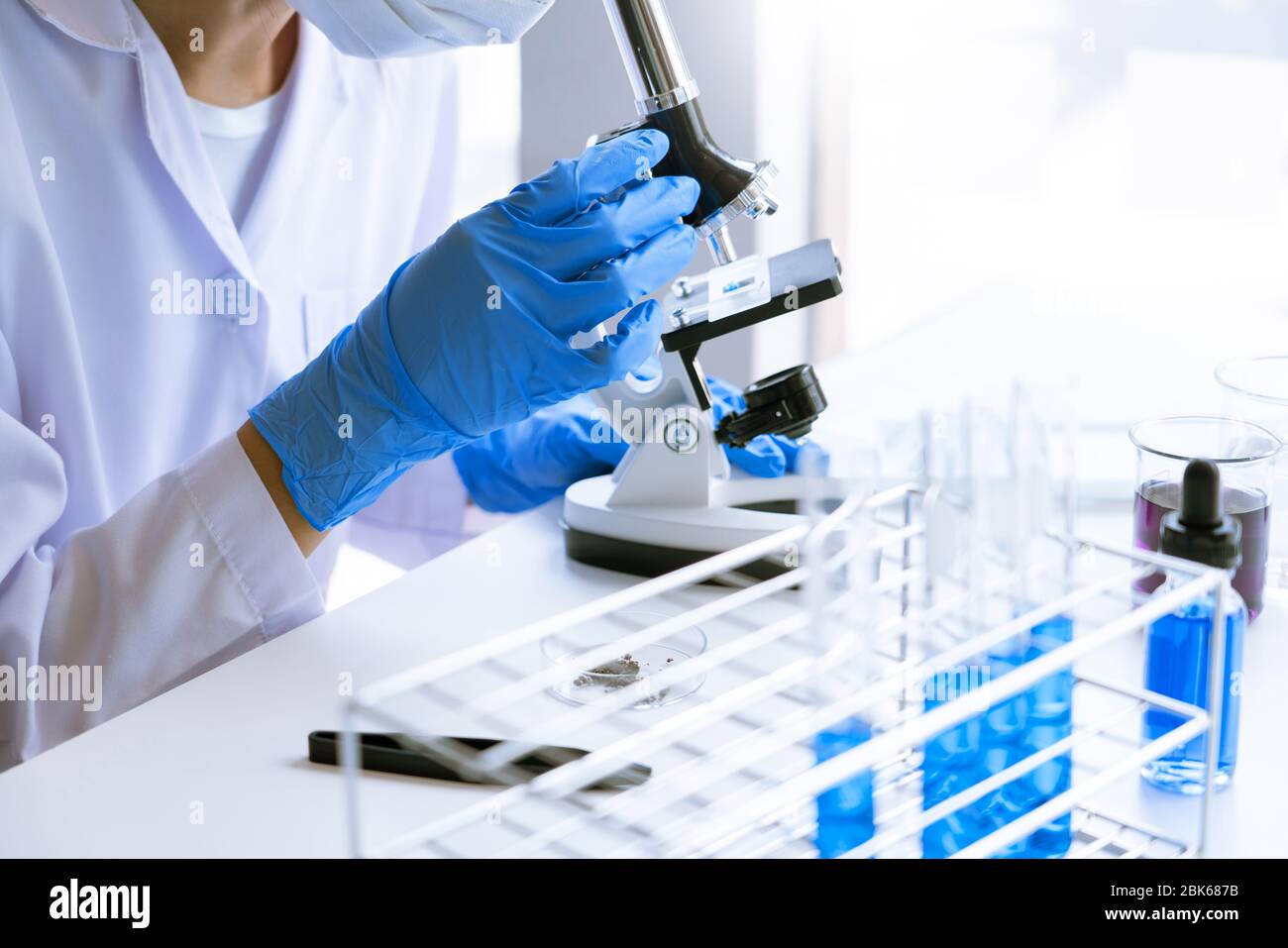 Young Asian scientist Working looking through a microscope doing ...