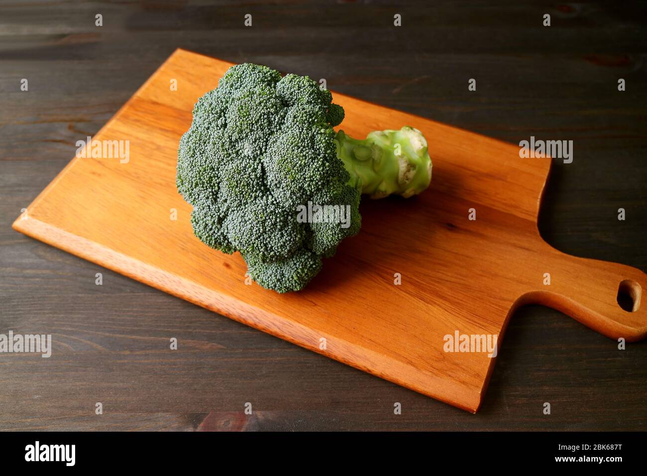 Raw broccoli isolated on a wooden chopping board Stock Photo