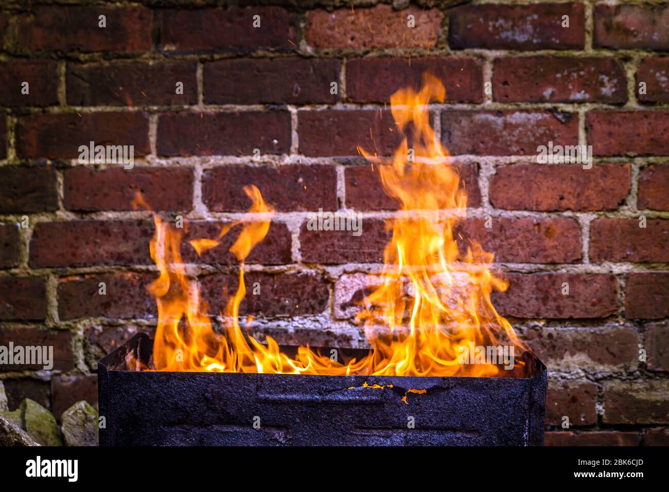 fire and grill over red brick wall background in backyard Stock Photo