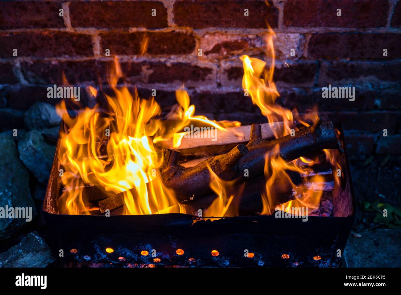 fire and grill over red brick wall background in backyard Stock Photo