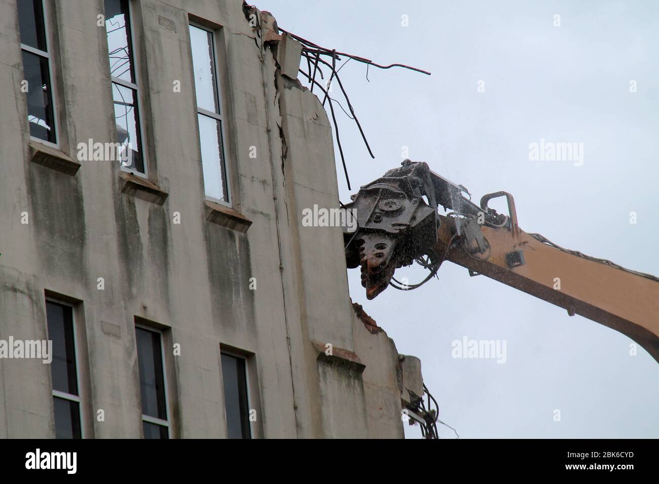 The Jaws of an Excavator Demolishing a Building. Stock Photo