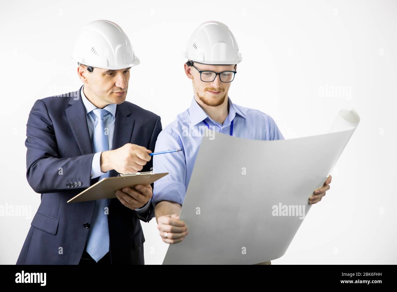 Architectural engineers working with blueprint documents discussing planing Stock Photo