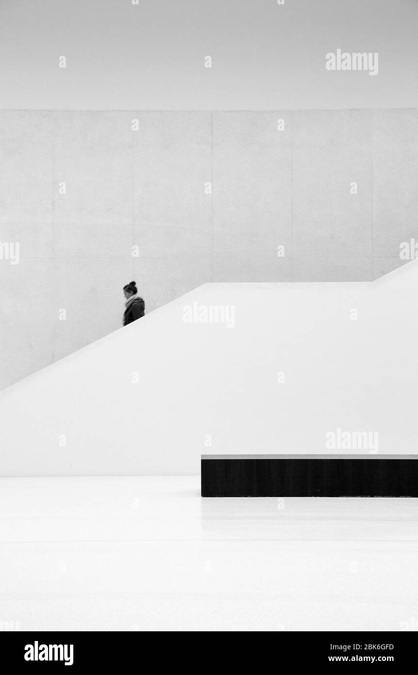 Modern geometric staircase with a person walking down Stock Photo