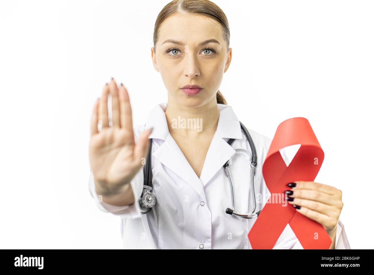 30s Female doctor with red ribbon for AIDS HIV awareness on white ...