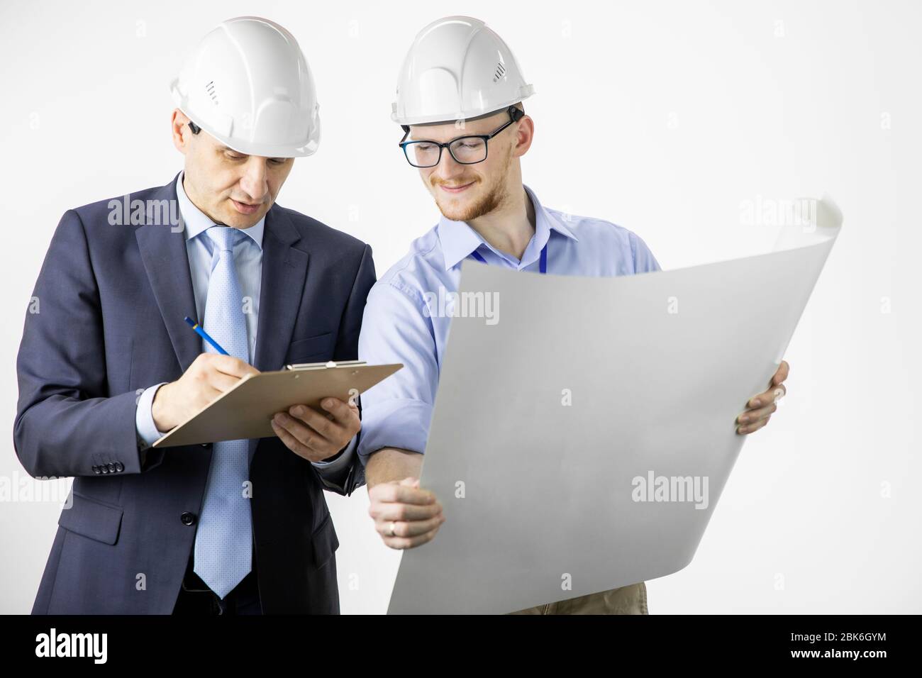 Engineers working with blueprint marking edits in documents on clipboard Stock Photo
