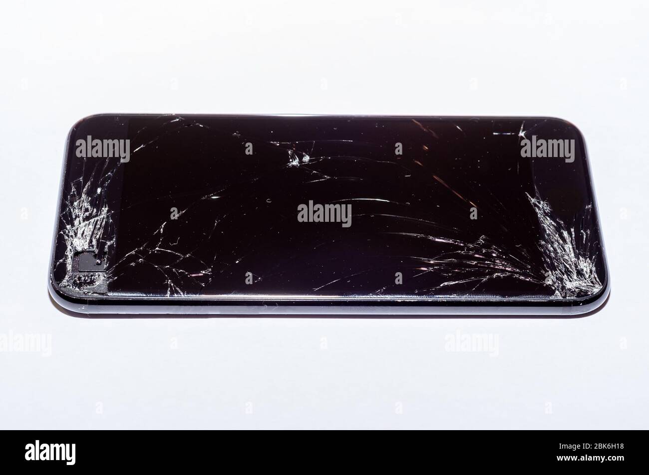 View on a cracked screen of a smartphone isolated on a white background ...