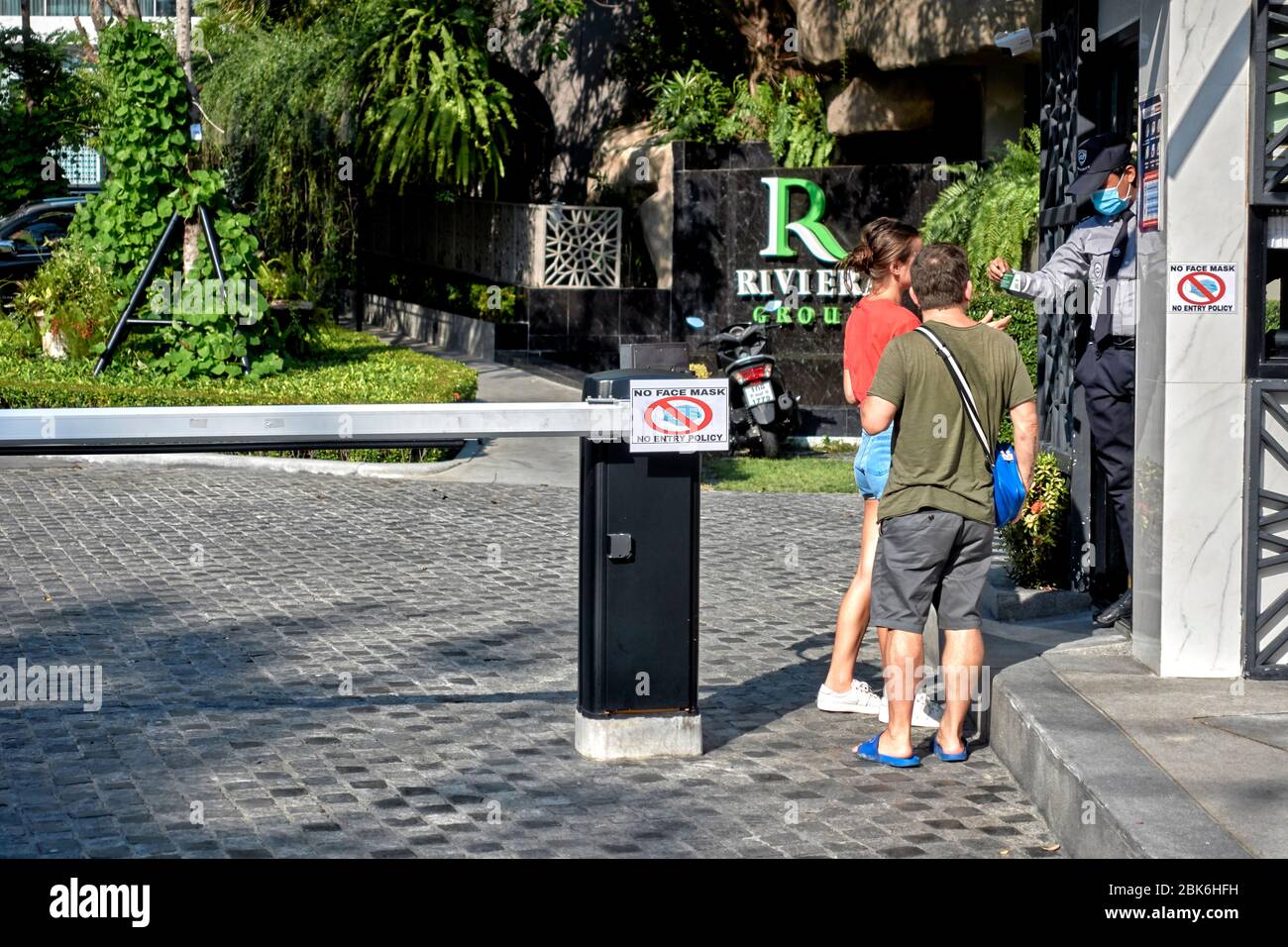 Covid-19 restriction. No mask no entry. Couple denied entry to a hotel by the security  guard for failure to wear face mask as indicated on the sign Stock Photo