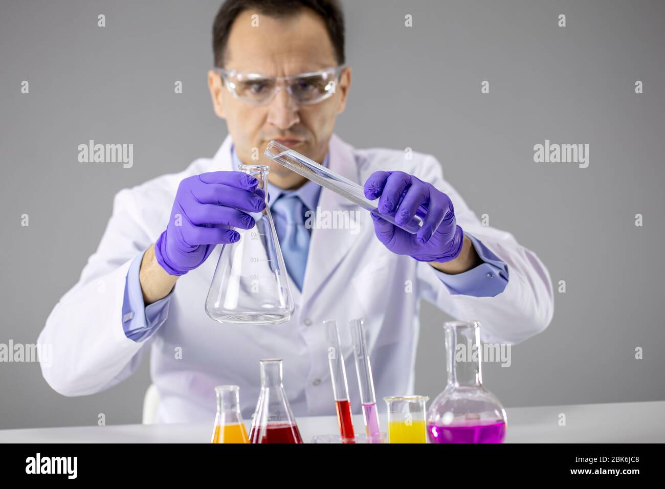 Lab Subordinate Lab attendant working in lab with reaction tubes, performing science ...