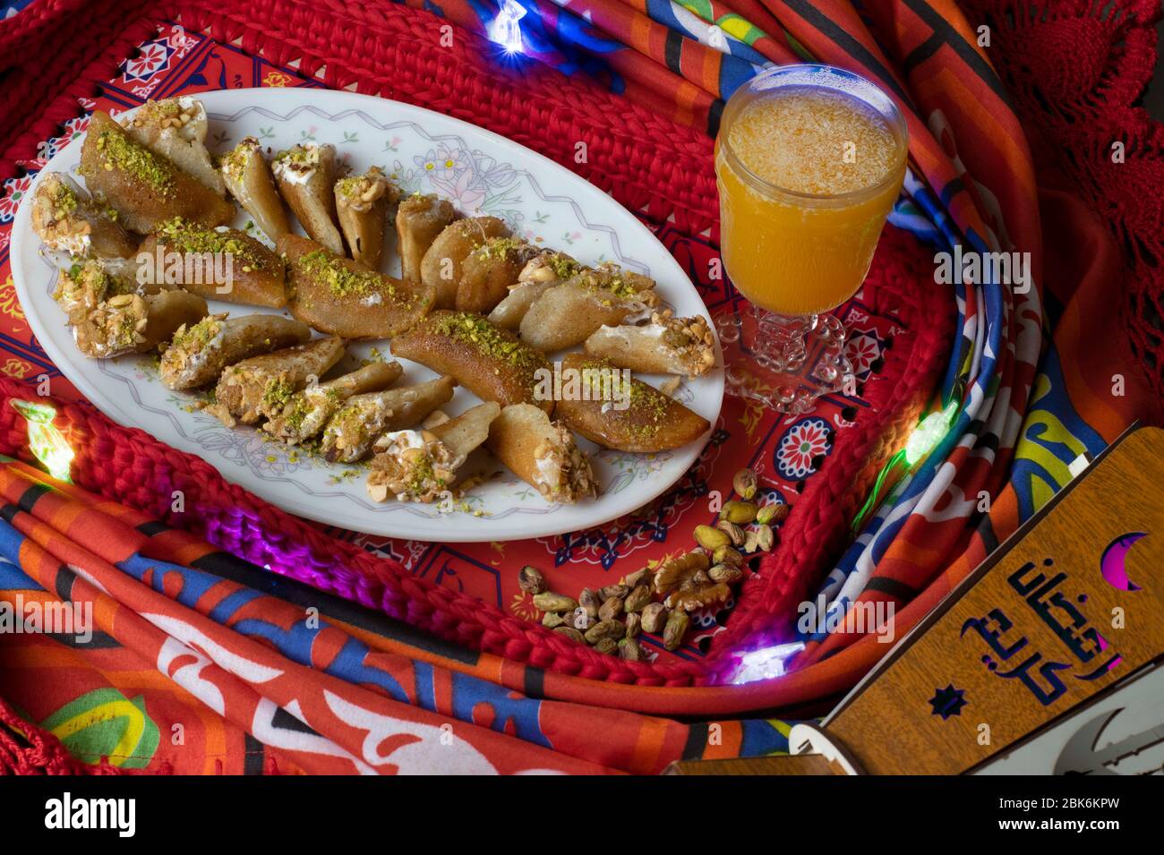 An oriental dessert called Atayef with nuts and an oriental drink called Amar el-din which are made specially in the holy month of Ramadan Stock Photo