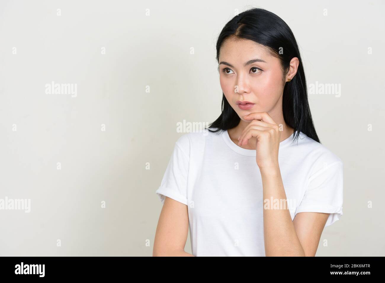 Portrait of young beautiful Asian woman thinking and looking up Stock ...
