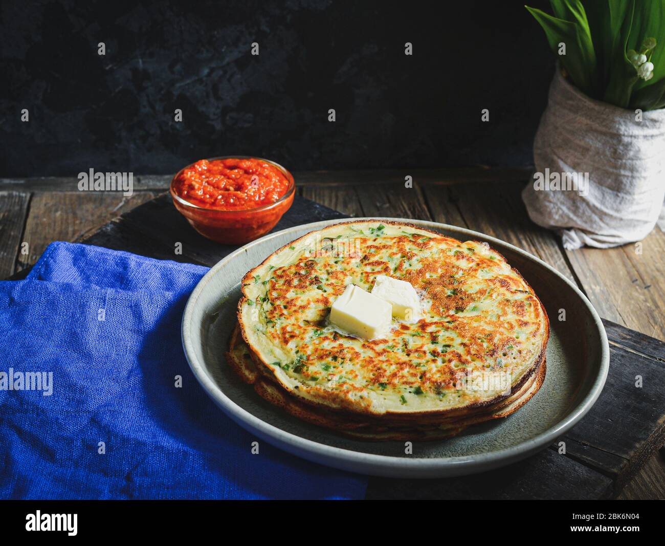 Thin pancakes with herbs. Salty Pancakes with green onions. Wood background. Vintage background. Delicious food for a bite to eat. Free space for text Stock Photo