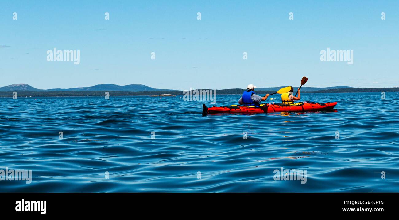 Two people kayaking alone in the very blue waters of Frenchmans Bay Bar Harbor. Stock Photo