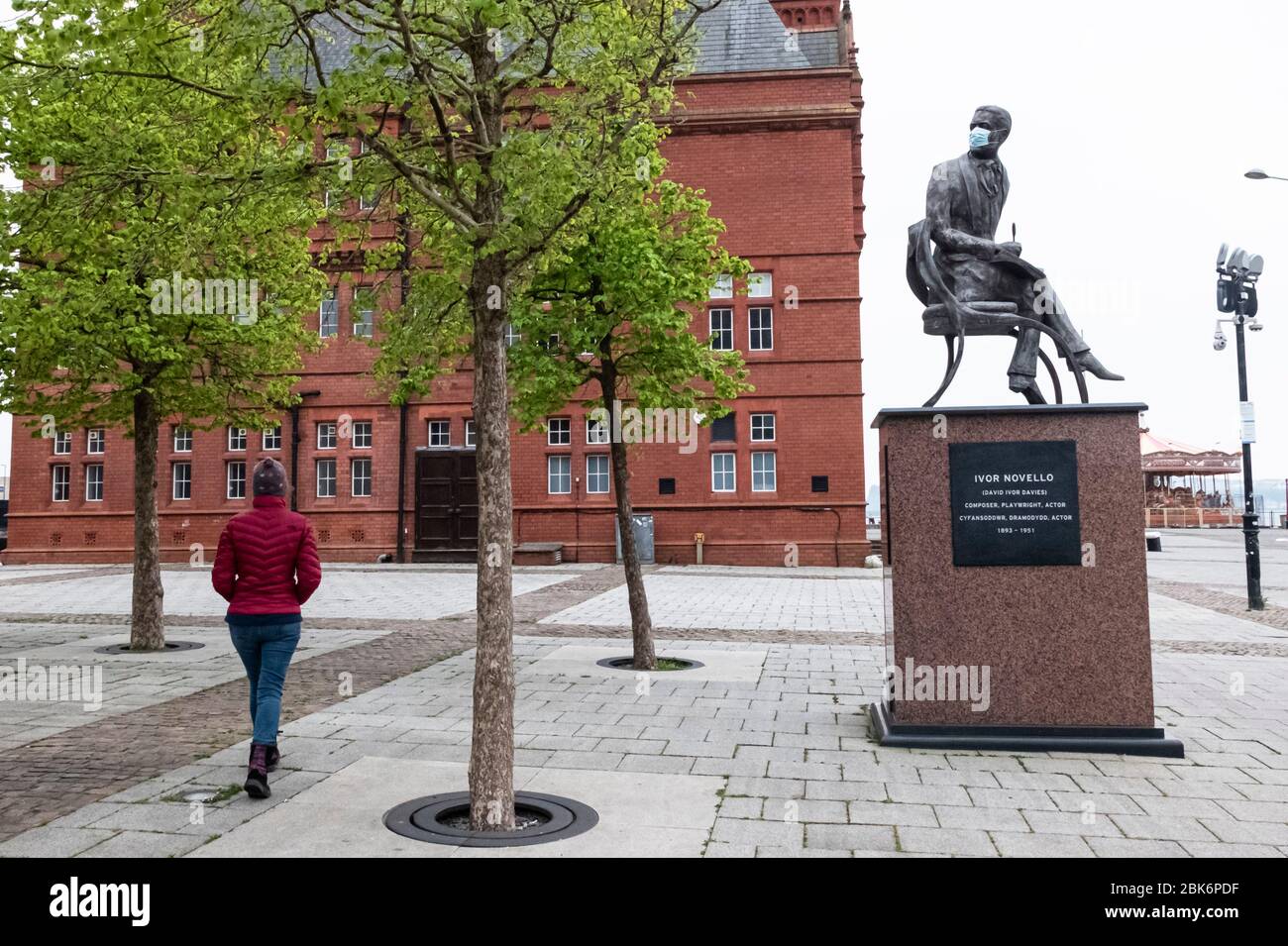 Statue of Welsh composer and actor Ivor Novello in Cardiff Bay, Wales, has his face covered with a face mask during the coronavirus COVID19 pandemic Stock Photo