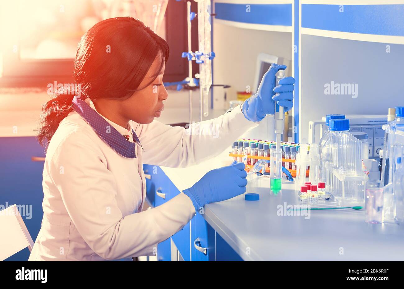 African scientist or graduate student in lab coat and protective wear