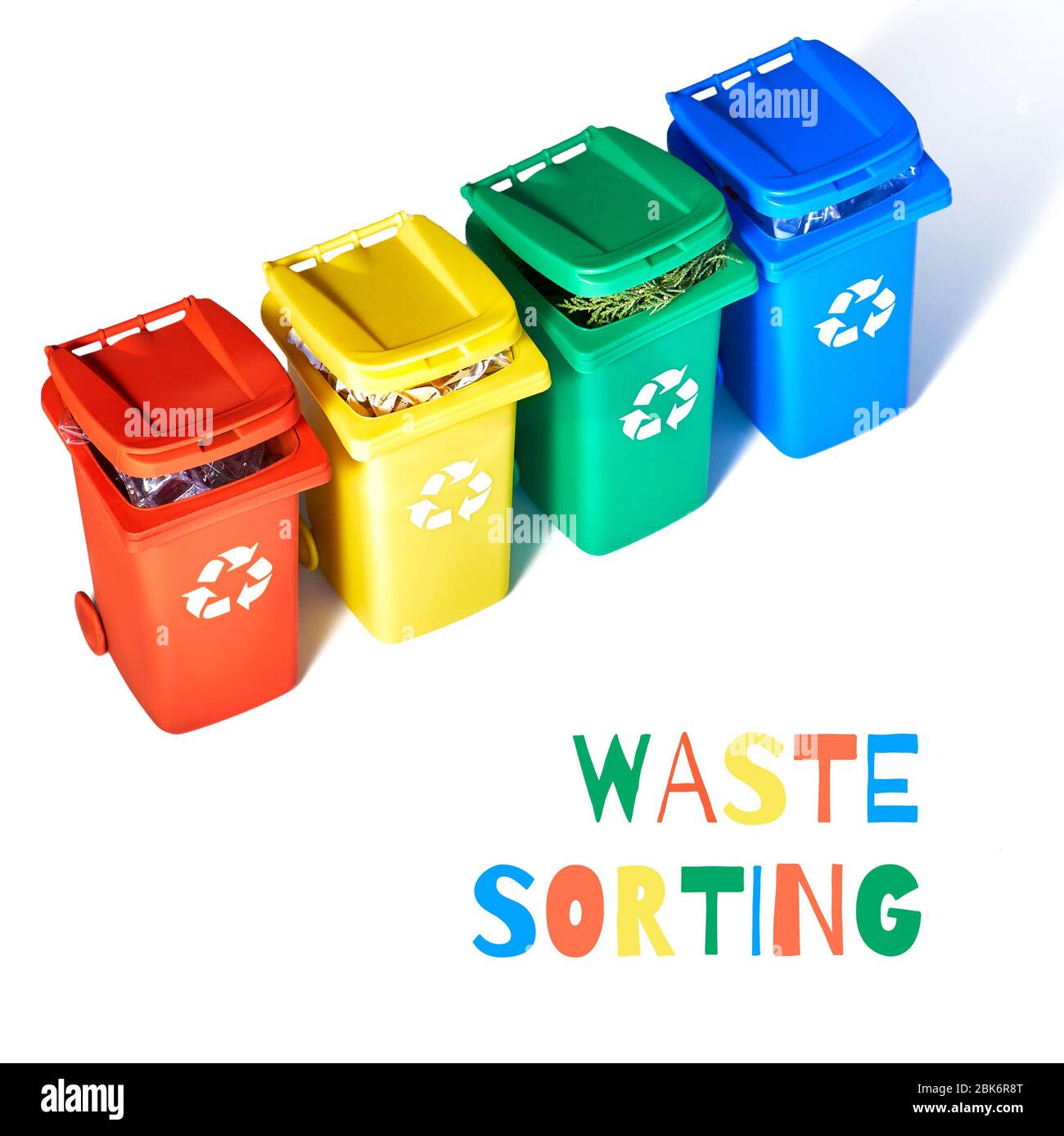 Four color coded recycle bins, isometric projection on white background, text 'Waste sorting'. Recycling sign on the bins - red, blue, yellow and gree Stock Photo