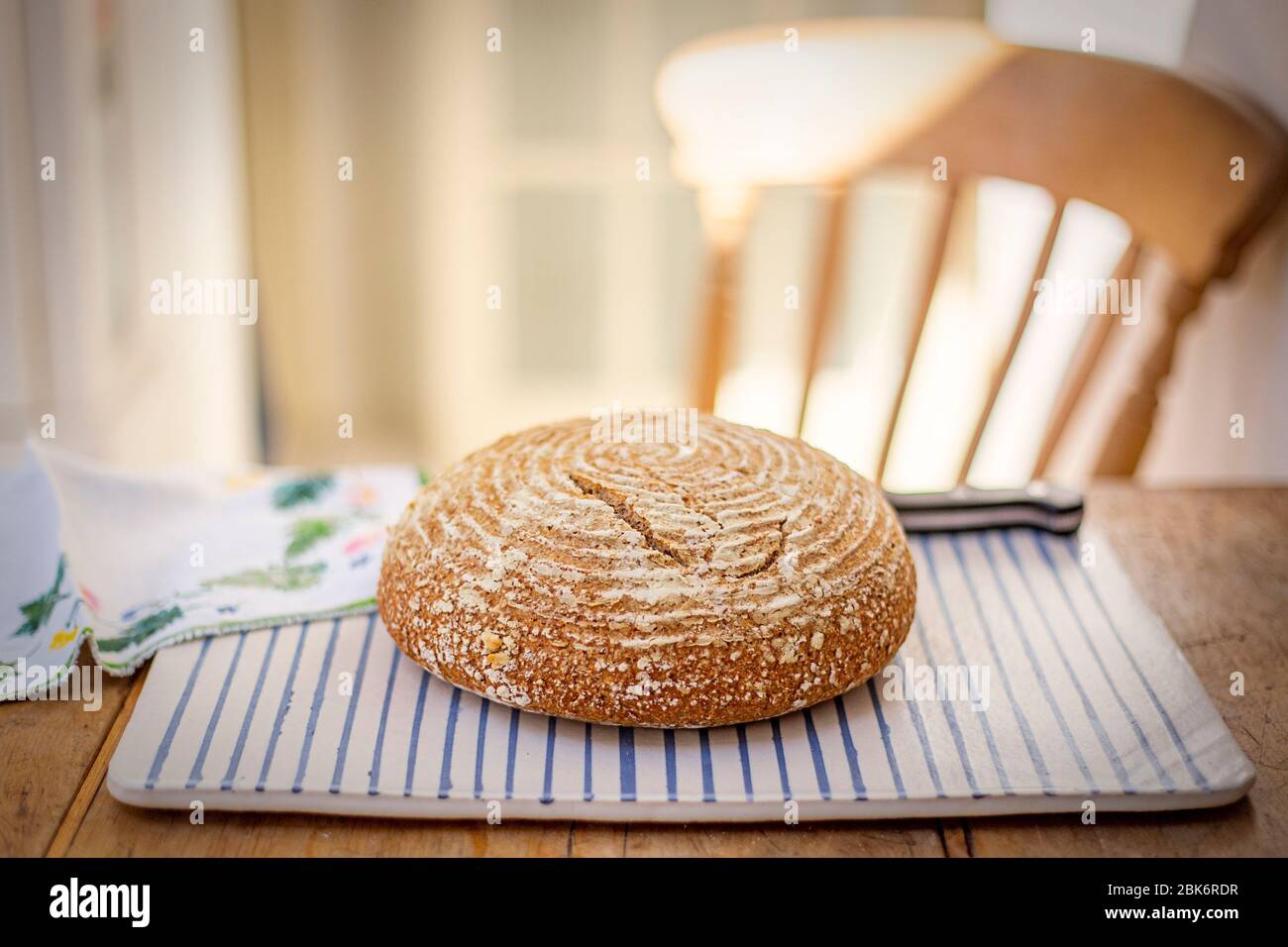 Home-made sourdough bread presented on a pottery plate (landscape format) Stock Photo