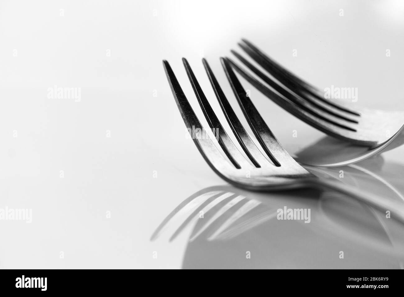 metal fork for food elegant dinner still life reflection on round mirror black and white classic background Stock Photo