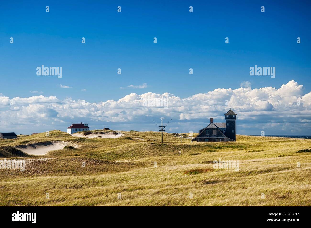 The tower and exterior of the old harbor life saving station rising above the grass covered dunes on the national seashore at race point in provinceto Stock Photo
