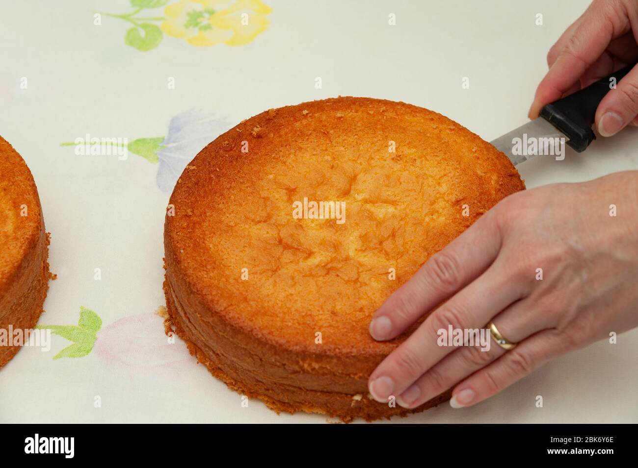 Making sponge cake. Cutting in half. Close-up. Top view. Horizontal shot. Stock Photo