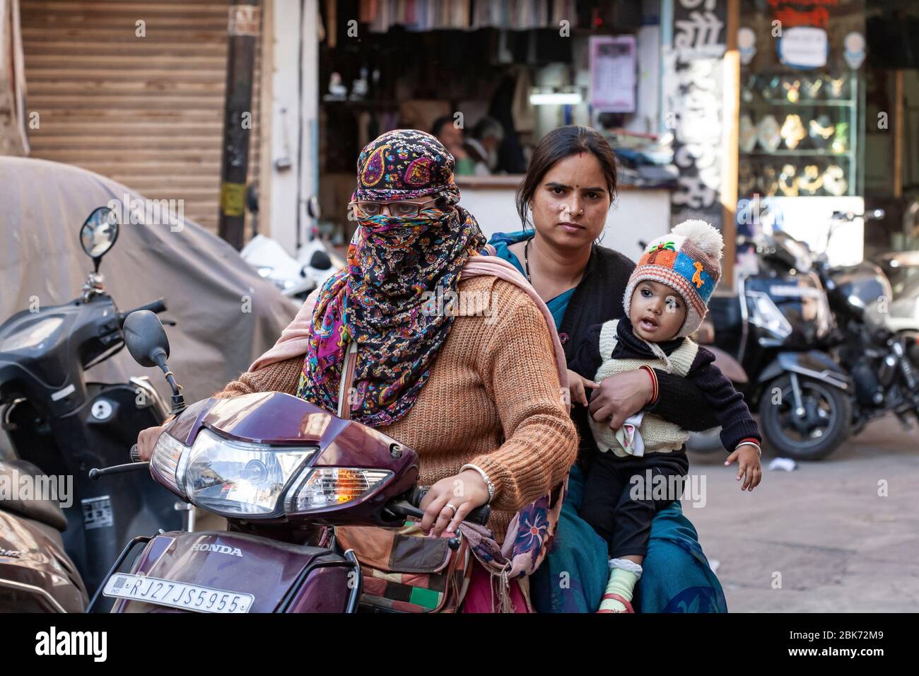 Udaipur city in India, February 8, 2018: Woman in scarf riding a motorbike in Udaipur center Stock Photo