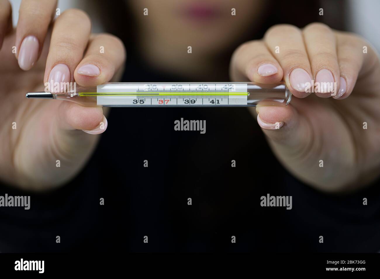 https://c8.alamy.com/comp/2BK73GG/girl-holds-medical-glass-thermometer-with-optimal-temperature-of-healthy-person-2BK73GG.jpg