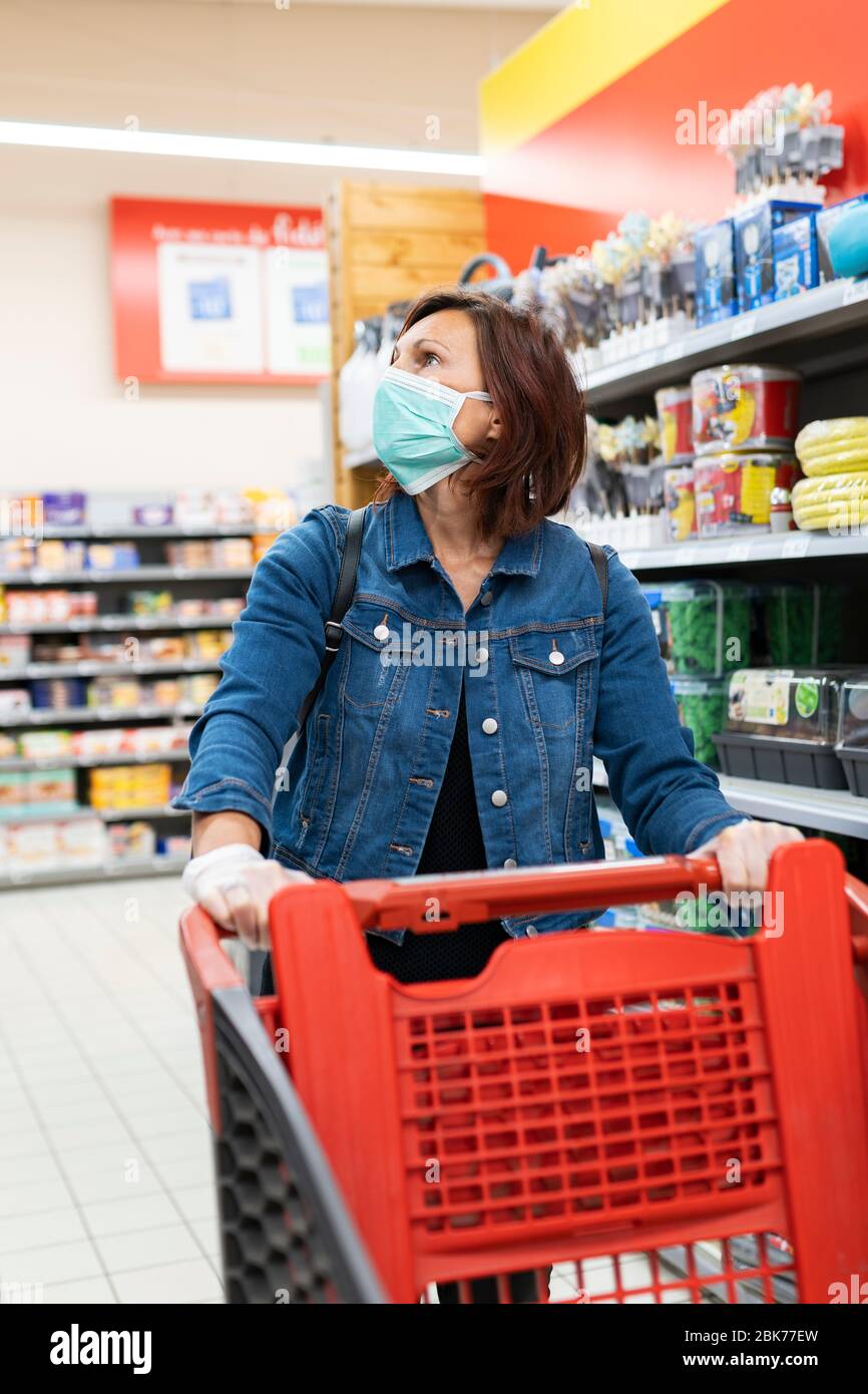 caucasian girl with mask in supermarket Stock Photo