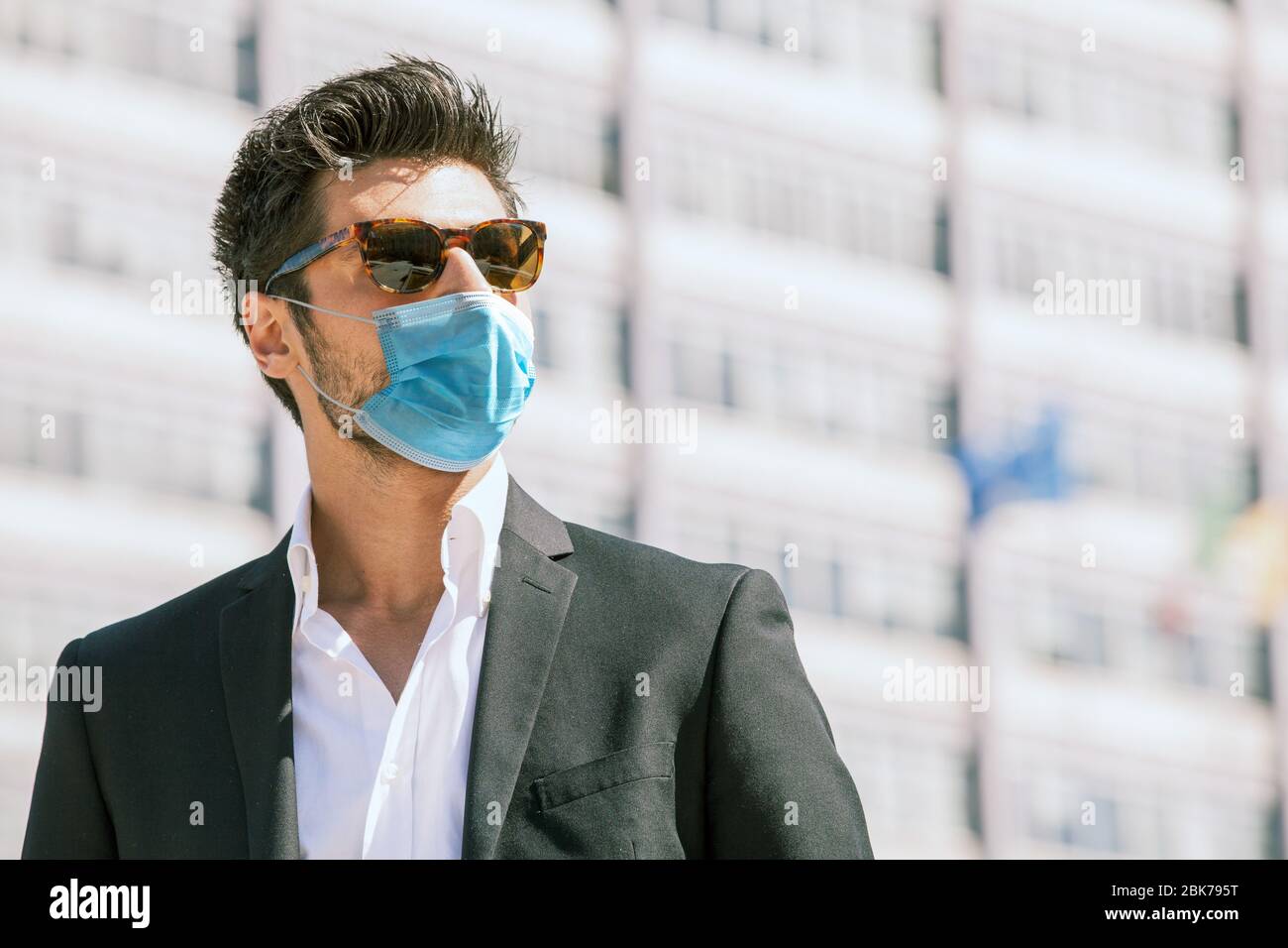 Young man with surgical face mask and sunglasses outdoors. Coronavirus ...