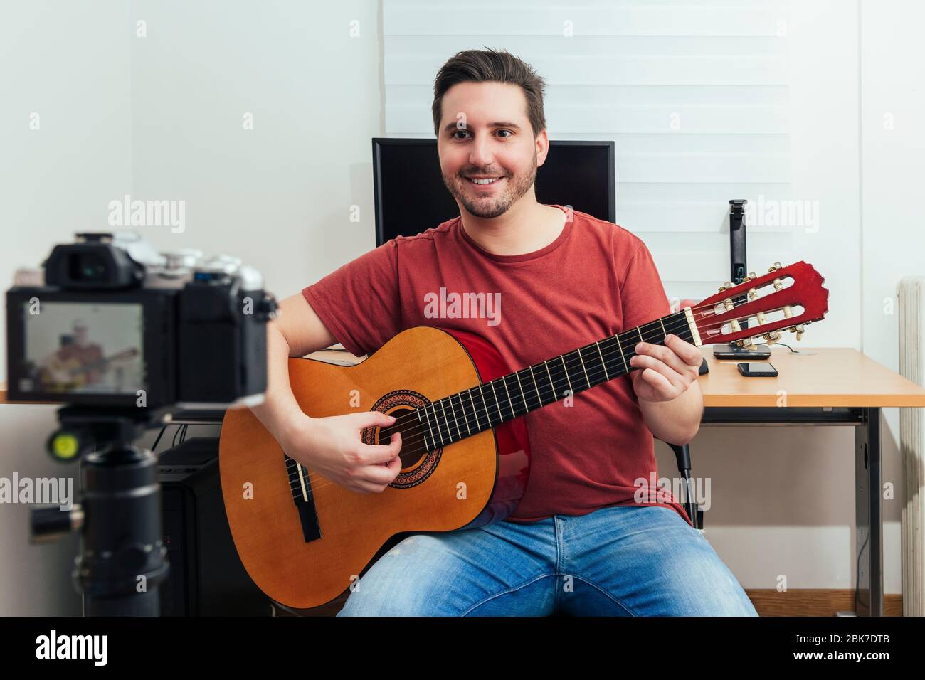 Blogger recording the guitar lesson from his home studio. Learning online concept. Stock Photo