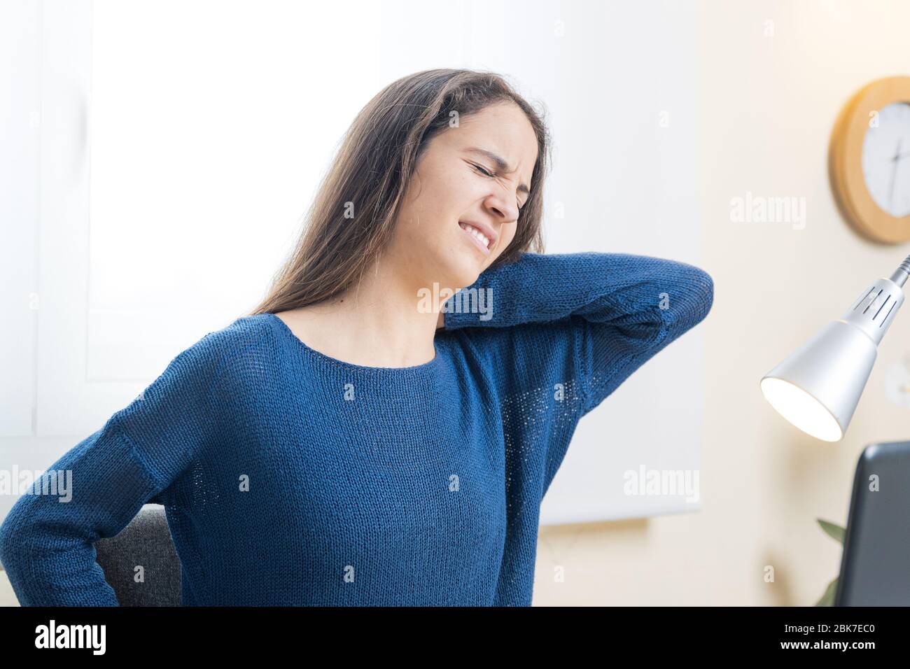 Teen student suffers neck pain with computer at home Stock Photo - Alamy