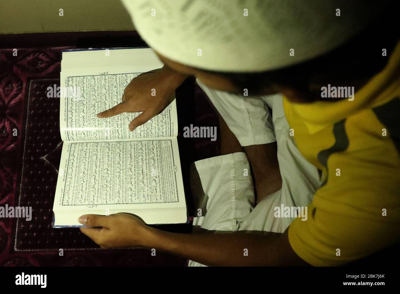 A Muslim man is seen reciting the holy Quran at home during the holy month of Ramada amid Coronavirus crisis.People should better say prayers at home as the Prophet Mohammad himself had given the same direction. Stock Photo