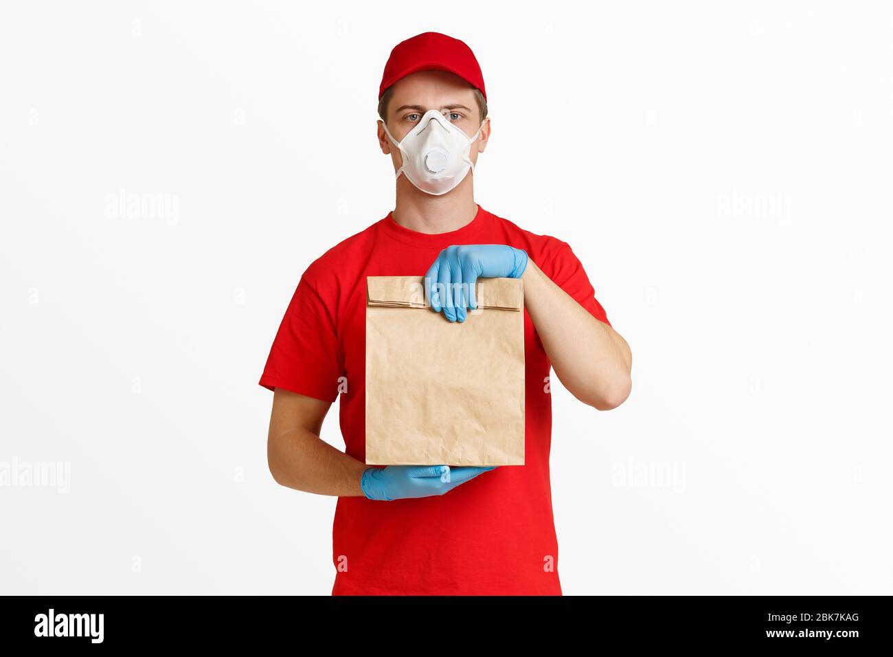 Courier in red uniform with package in hands Stock Photo