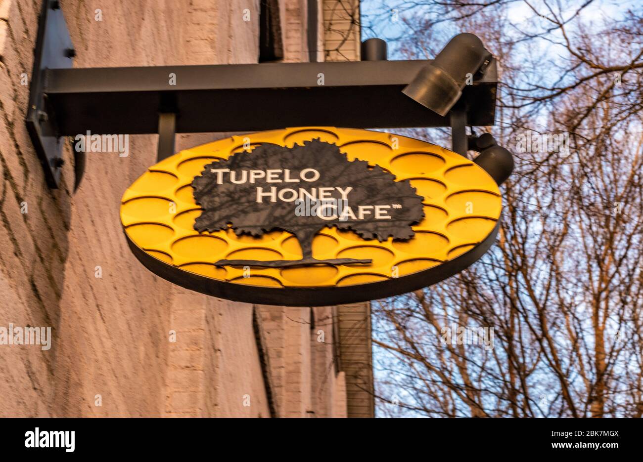 Charlotte, NC/USA - December 26, 2019: Medium closeup of uniquely creative 'Tupelo Honey Cafe' hanging sign showing brand and logo. Stock Photo
