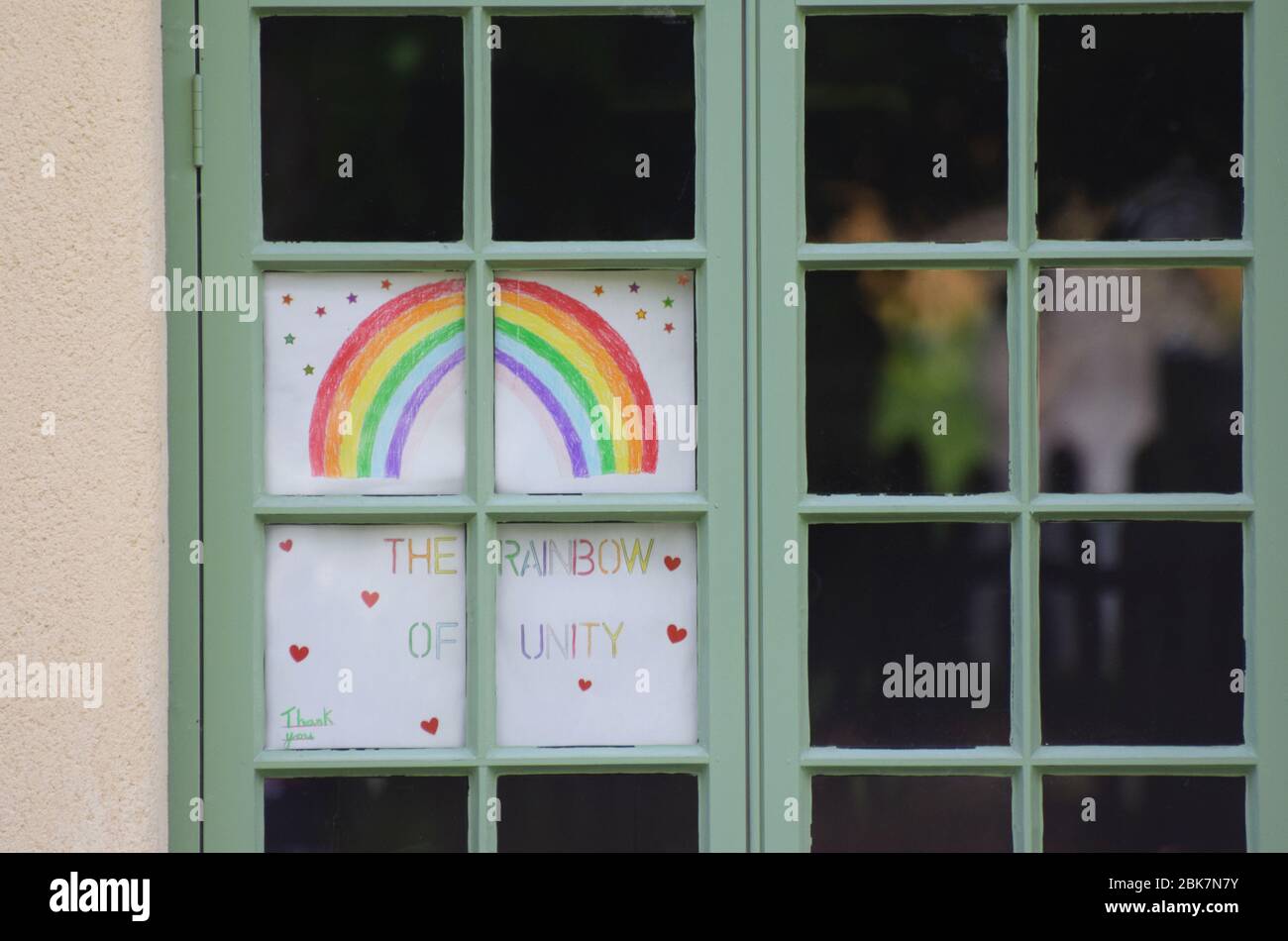 A home made rainbow painting in a house window in the UK during the 2020 Covid-19 pandemic Rainbows in windows at this times symbolised unity in hope Stock Photo