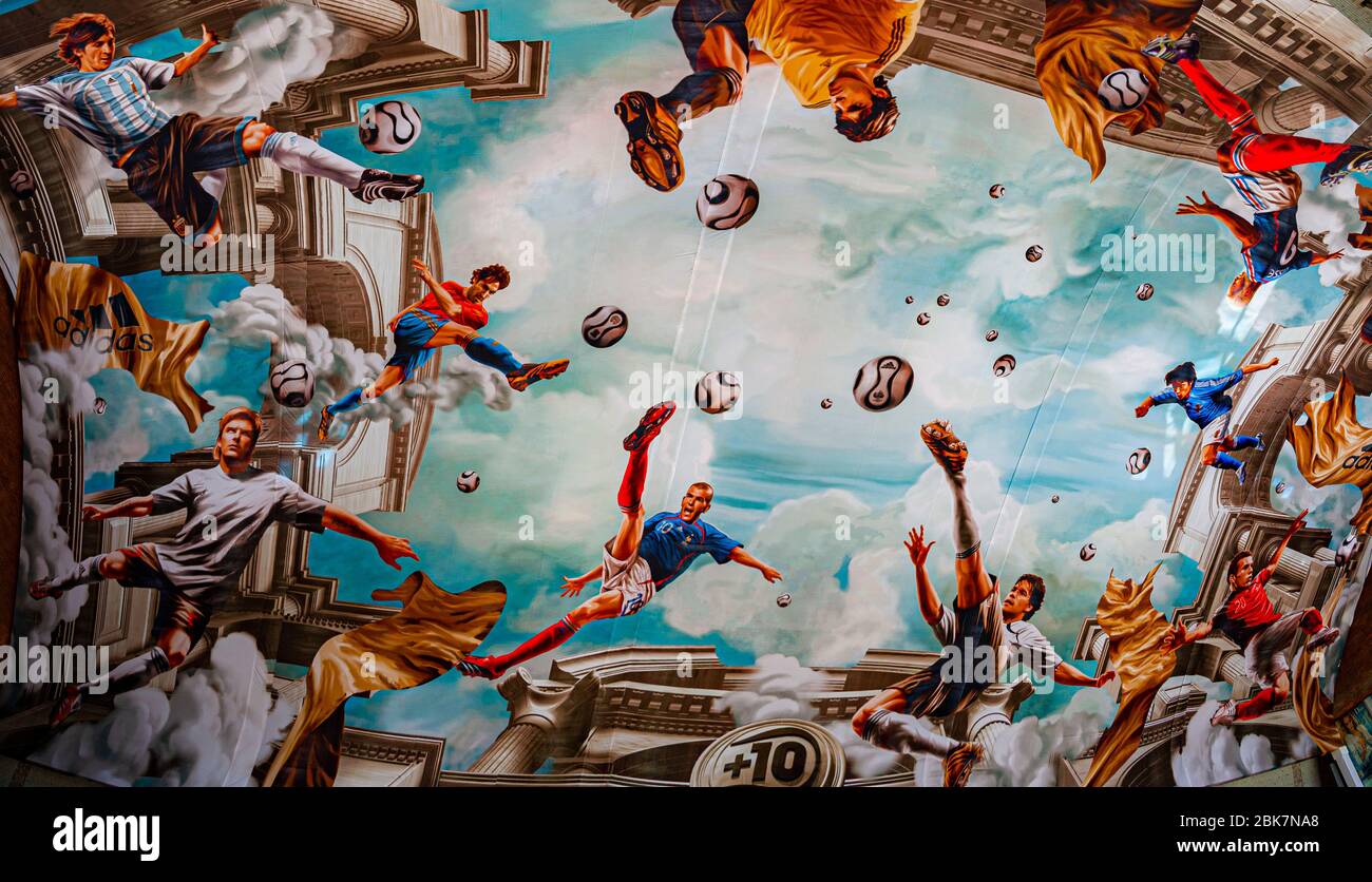 Marouflage (ceiling painting) with soccer scenes during the FIFA World Cup 2006 in Cologne Central Station. On an area of more than 800 square meters, Adidas has had a fresco installed on the ceiling of Cologne's main train station. In a true-to-the-original antique look, national players such as Michael Ballack, David Beckham, Zinédine Zidane and Juan Román Riquelme float high above the heads of passers-by Stock Photo