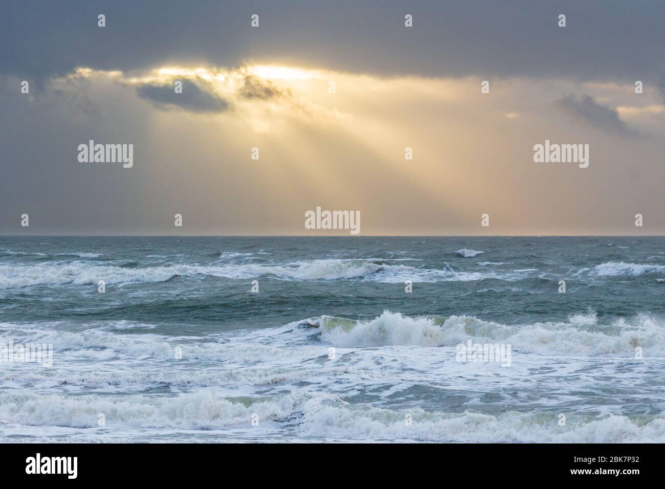 Sunbeams breaking through dark clouds above churning North Sea Stock ...