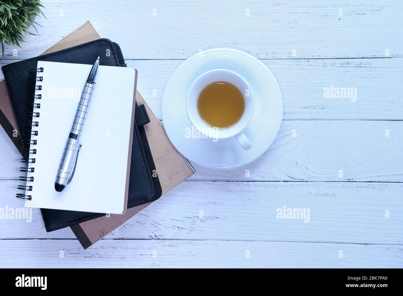 stack of notebooks and a tea cup on table Stock Photo