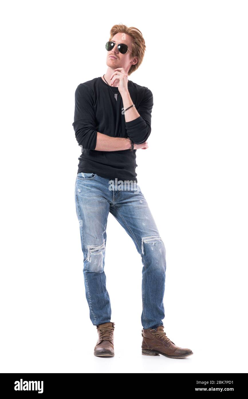 Serious thinking young handsome redhead man with hand on chin looking up over shoulder. Full body isolated on white background. Stock Photo