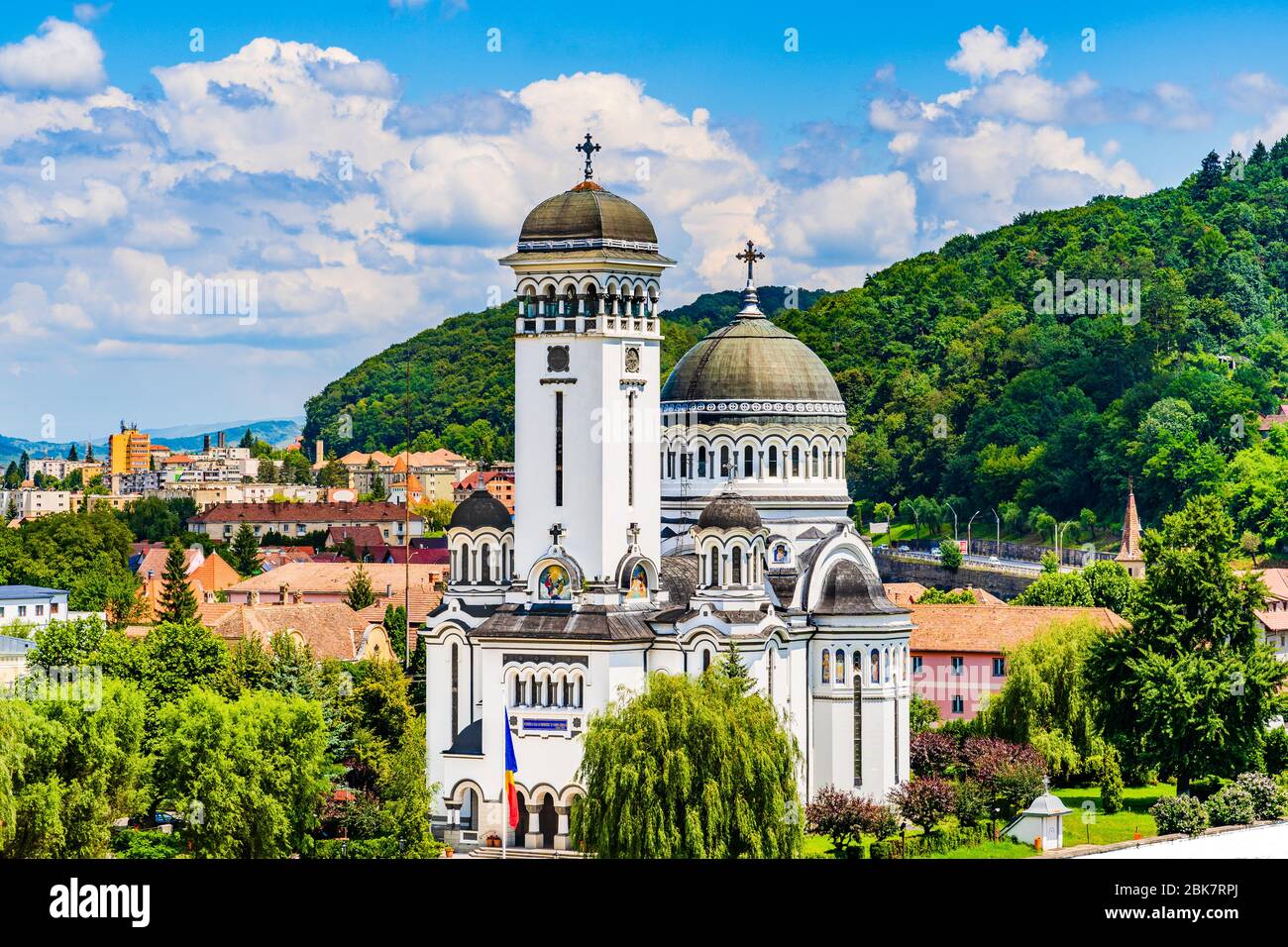 Sighisoara, Mures County, Romania: Landscape of The Holy Trinity (Stanta Treime) Orthodox church surrounded by home roof tops and green trees on a bac Stock Photo