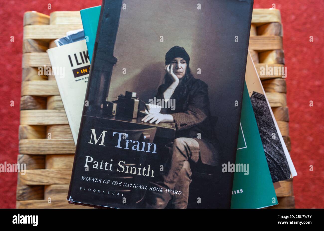 A copy of M Train a memoir by Patty Smith on top of a stack of books Stock Photo