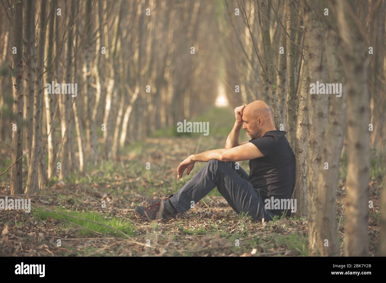 Sitting man with depression going through a rough patch in his life, suffering from mental exhaustion, anxiety, burnout Stock Photo