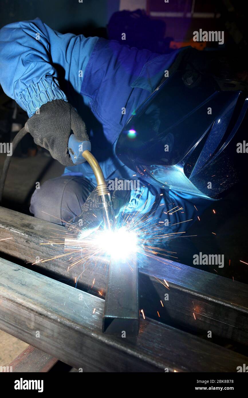 Welding. electric arc welding. The worker welding two iron corners. Stock Photo