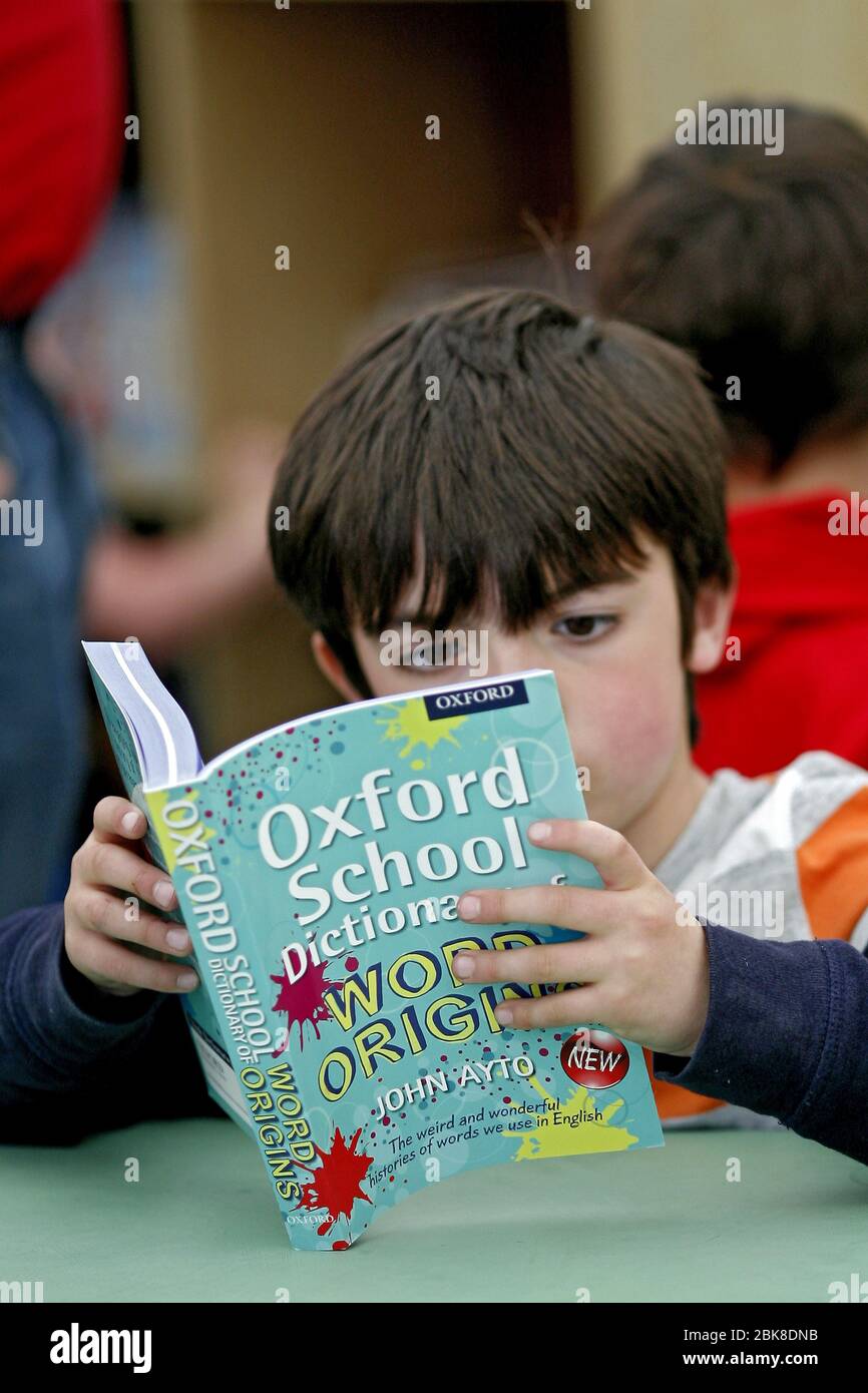 Hay-On-Wye, Hay Festival,  25th of May 2013,  a young boy reads a John Ayto book at Hay Festival. ©PRWPhotography Stock Photo
