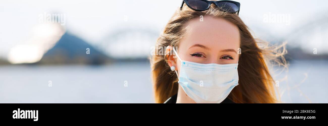 Young blonde woman in surgical mask and glasses on top banner Stock Photo
